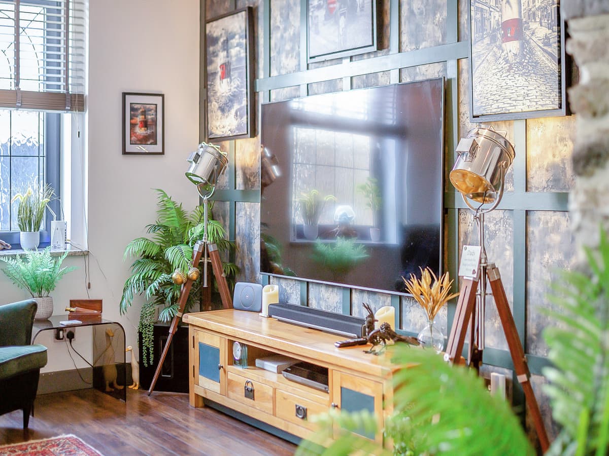 Lounge TV wall with 75" tv. Green mottled wall paper inside panelling