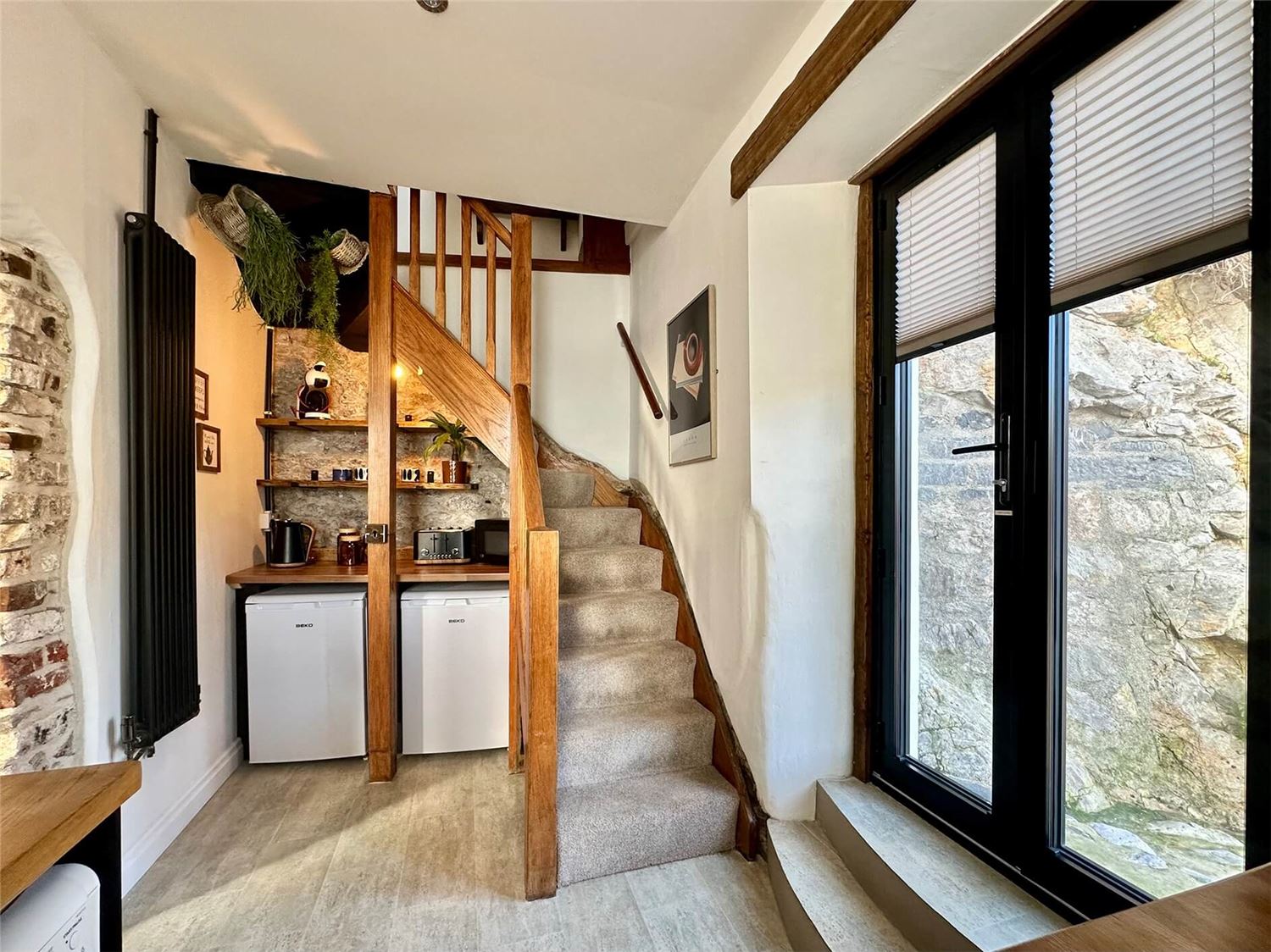 Kitchenshot towards the coffee and tea corner under the stairs. French door to the right straight down to the sea